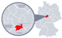 Diese Grafik zeigt eine Karte von Deutschland mit einer detaillierten Ansicht der Region Südniedersachsen-Harz. Südniedersachsen-Harz ist in Rot hervorgehoben und liegt mittig in Deutschland. Ein Lupensymbol vergrößert diesen Bereich, um die Lage genauer darzustellen.