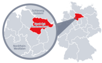 Diese Grafik zeigt eine Karte von Deutschland mit einer detaillierten Ansicht der Region Nord-Ost-Niedersachsen. Nord-Ost-Niedersachsenist in Rot hervorgehoben und liegt im nördlichen Teil Deutschlands. Ein Lupensymbol vergrößert diesen Bereich, um die Lage genauer darzustellen.